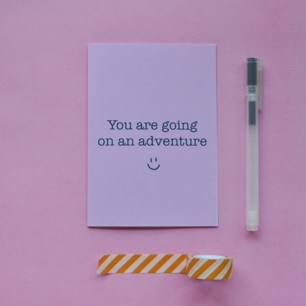 Roze kaart met de tekst 'you are going on an adventure' en een lachend gezichtje eronder.