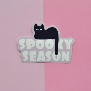 Sticker met de tekst spooky season voor halloween, met een illustratie van een zwarte kat