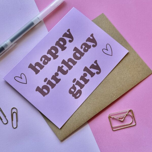 roze verjaardagskaart met rode letters en hartjes en de tekst 'happy birthday girly'